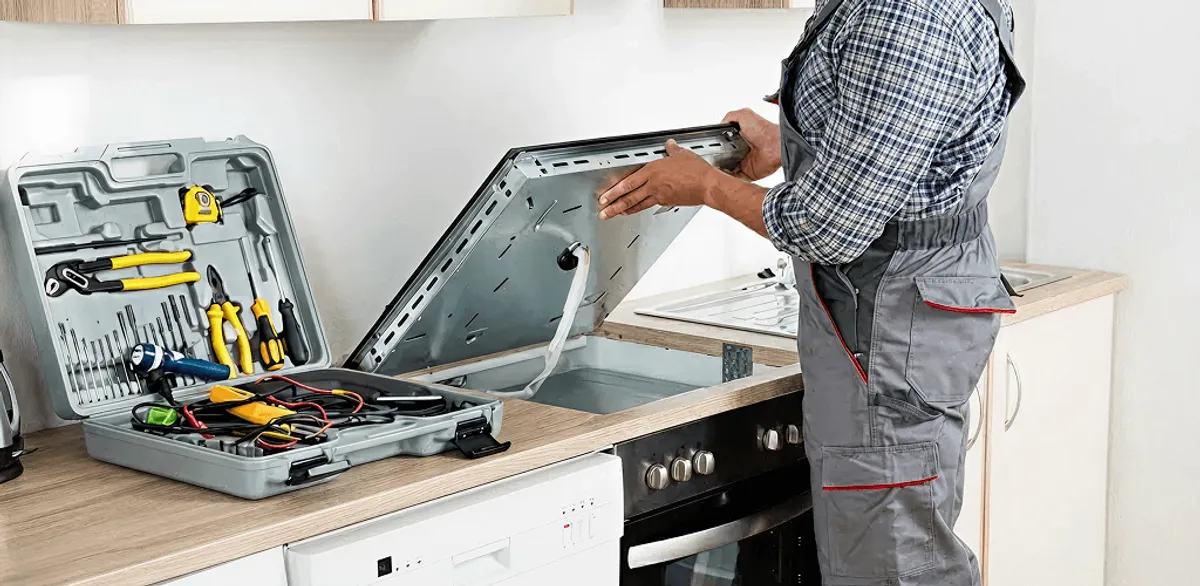 Handyman repairing a cooktop and checking wiring connections in Manchester, NH