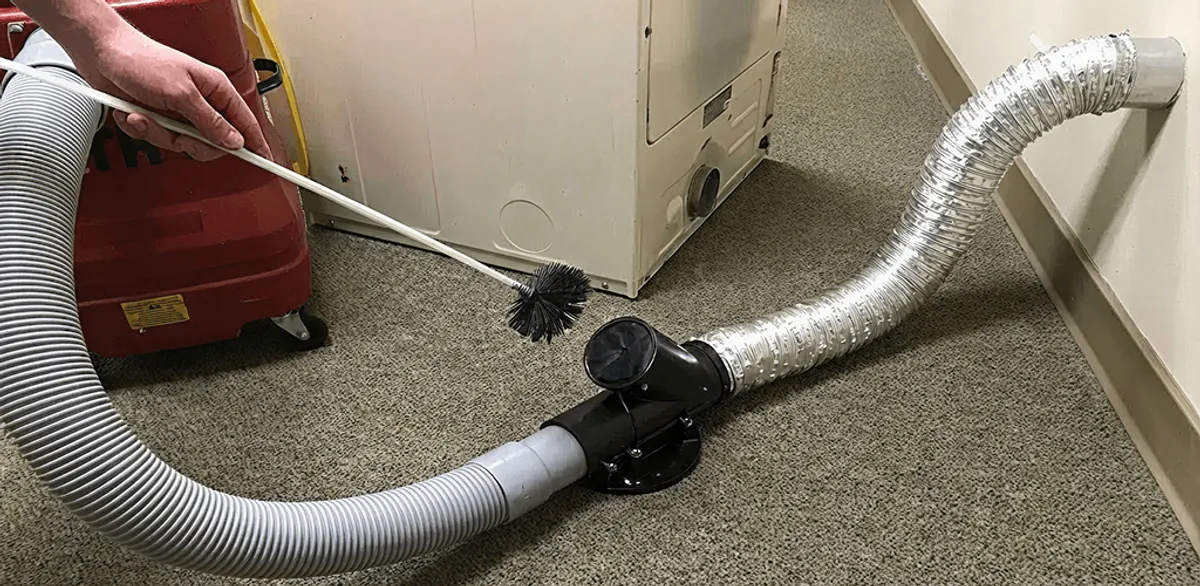 Dryer vent cleaning service removing lint from a dryer duct connection in Manchester, NH