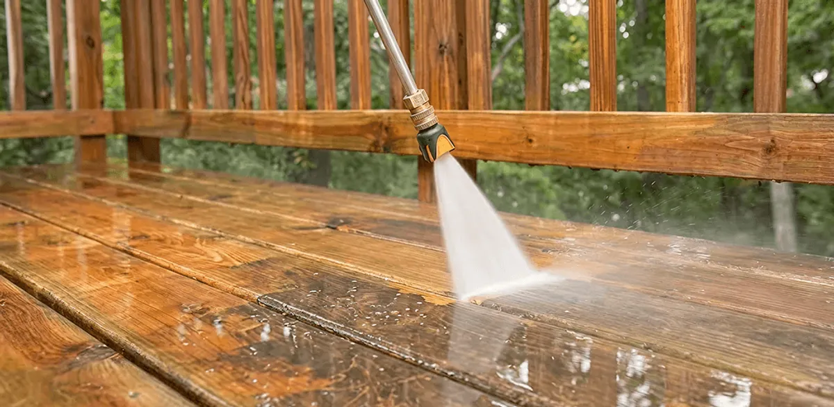 Pressure washing a wood deck to remove dirt and buildup in Manchester, NH